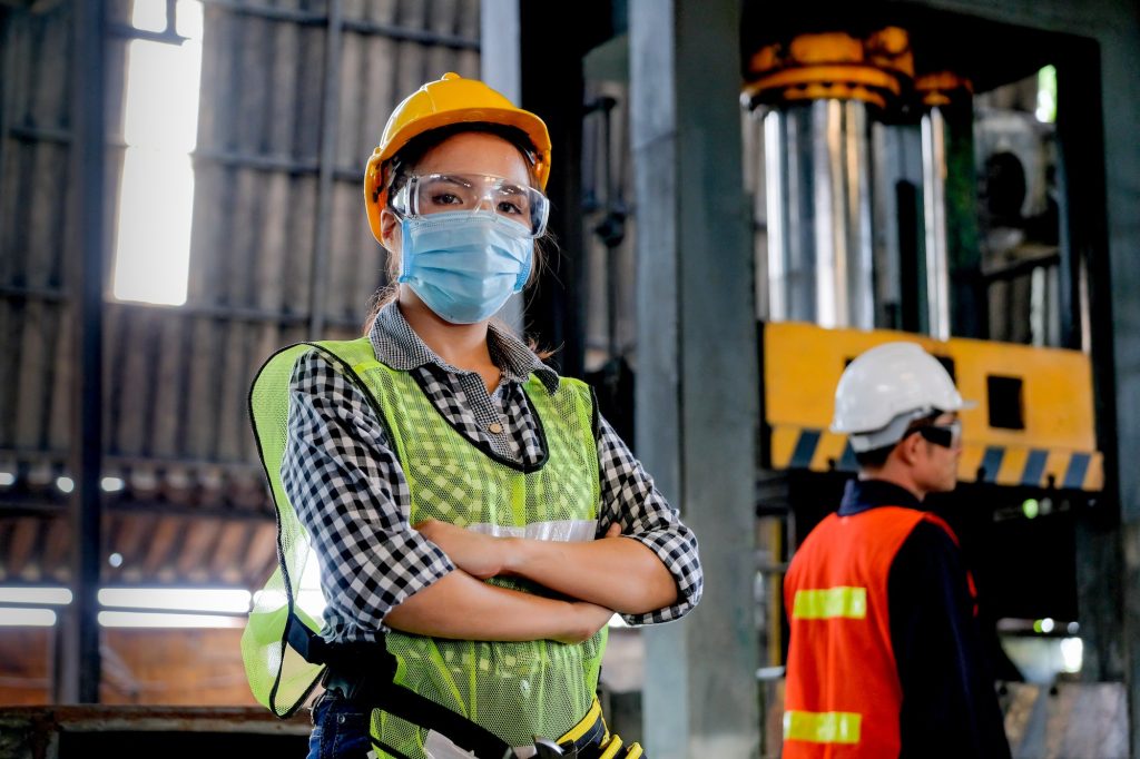 Factory woman worker or technician with hygienic mask stand with confident action with her co-worker
